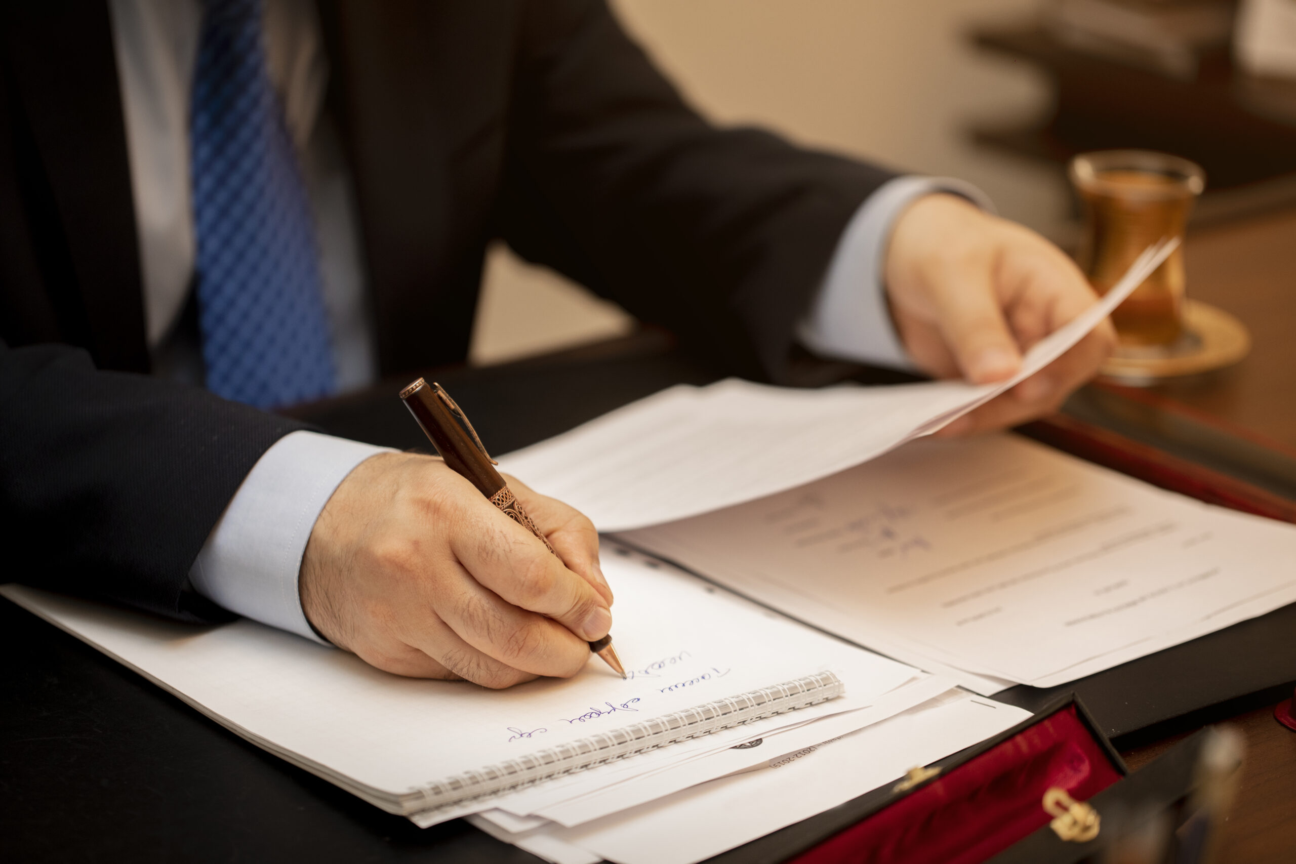 Businessman signing important contract papers obsługa prawna przedsiębiorstw
